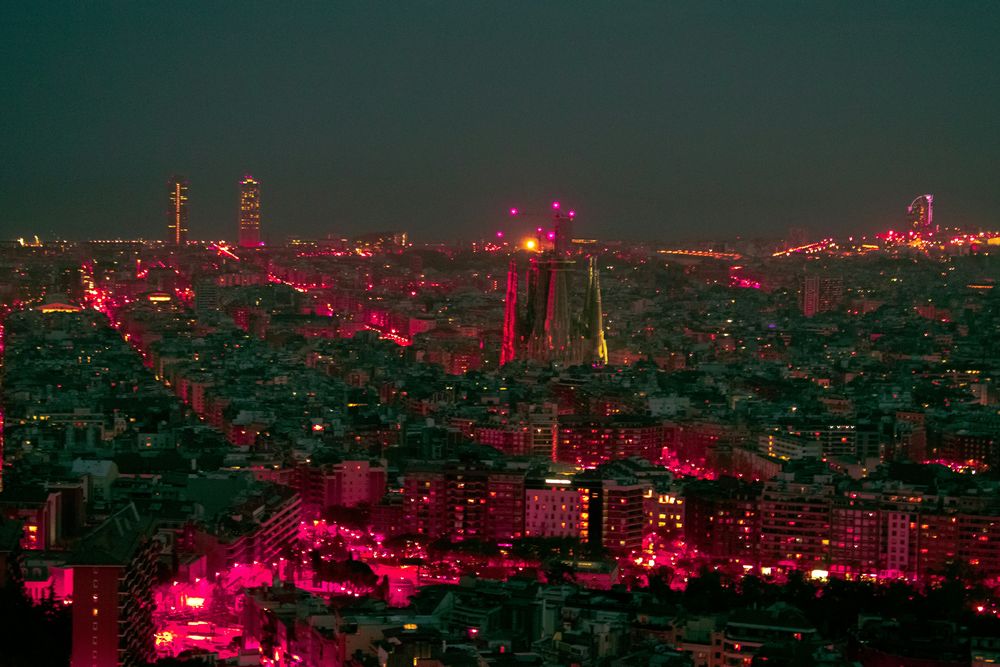 Barcelona bei Nacht von einem erhöhten Punkt aus, in der Bildmitte die Türme der Sagrada Família über dem Häusermeer