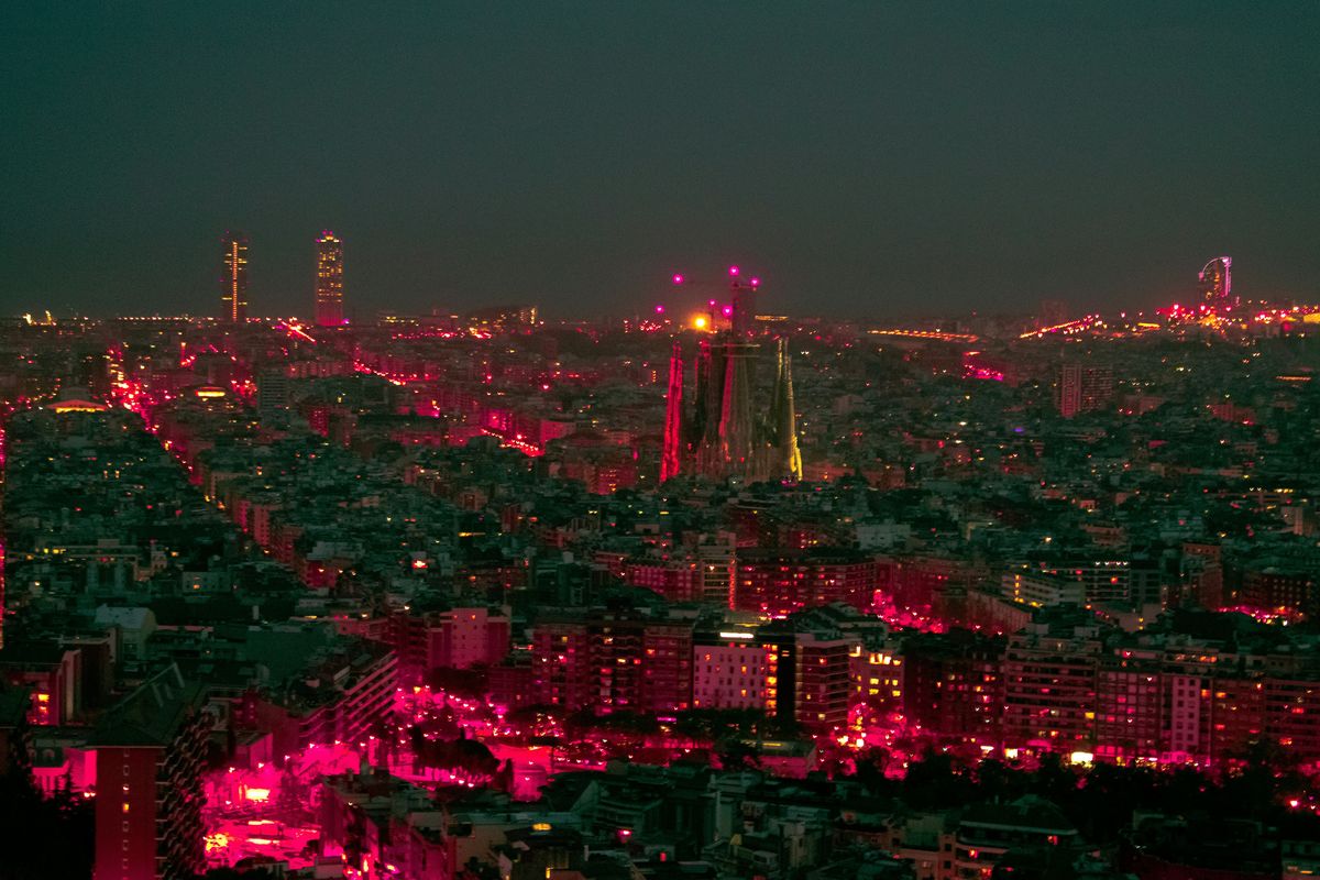 Barcelona bei Nacht von einem erhöhten Punkt aus, in der Bildmitte die Türme der Sagrada Família über dem Häusermeer